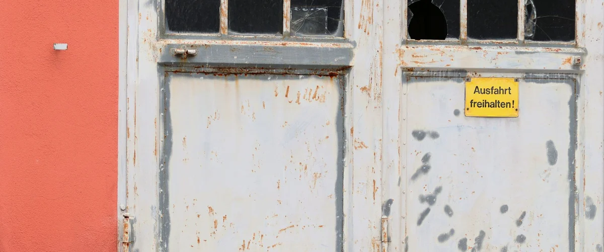 Einbruchschutz vorbeugen: Eine Frau sichert ein Fenster mit einem zusätzlichen Riegel in ihrem modernen Zuhause.