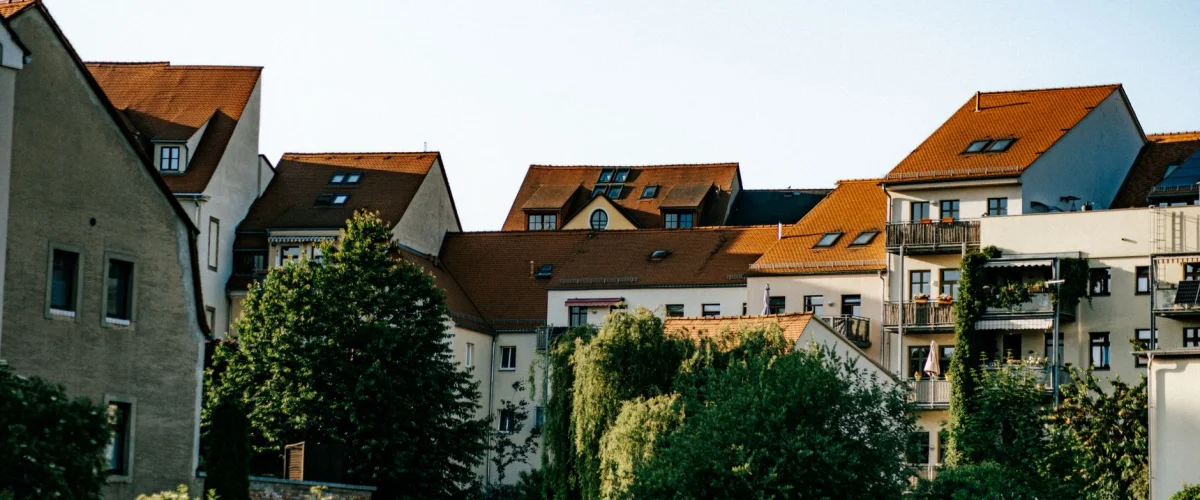 Nachbarschaftsrecht Bedeutung: Zwei Nachbarn unterhalten sich freundlich über einen Gartenzaun hinweg, symbolisch für ein gutes Miteinander.