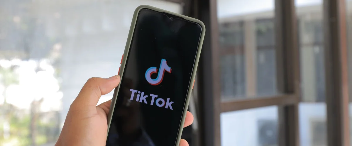 TikTok für Unternehmen Anleitung: Eine junge Frau erstellt ein Kurzvideo für ihr Geschäft, um Produkte zu bewerben und ihre Community zu erreichen.