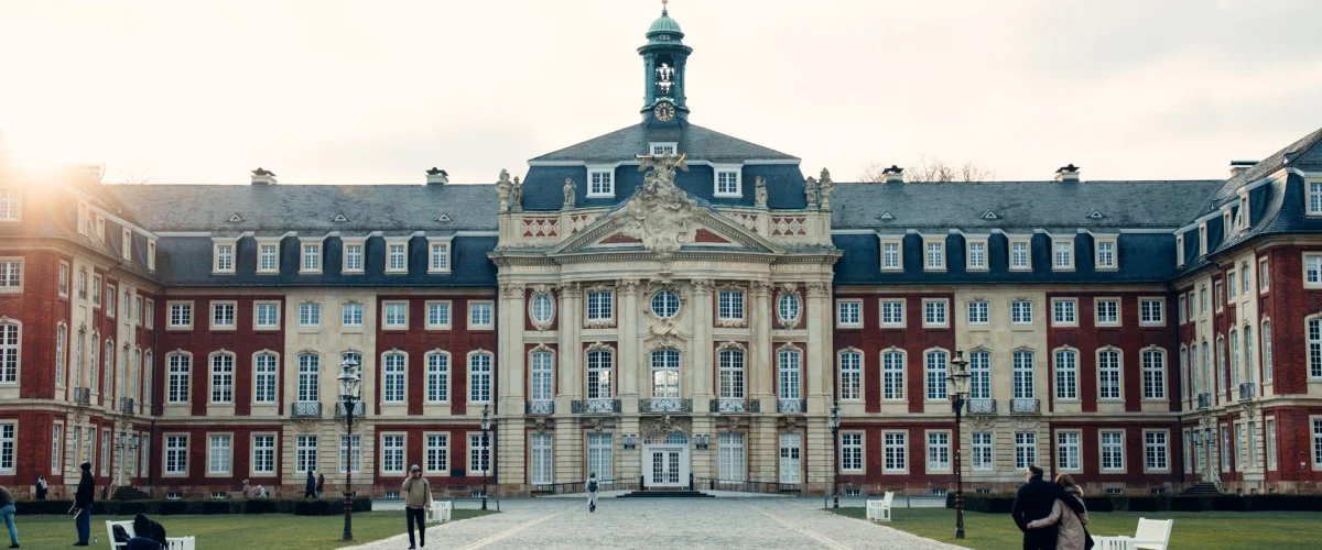 Auslandssemester Überblick: Eine Studentin sitzt vor einem Laptop und plant ihren Auslandsaufenthalt mit Globen und Reiseführern im Hintergrund.