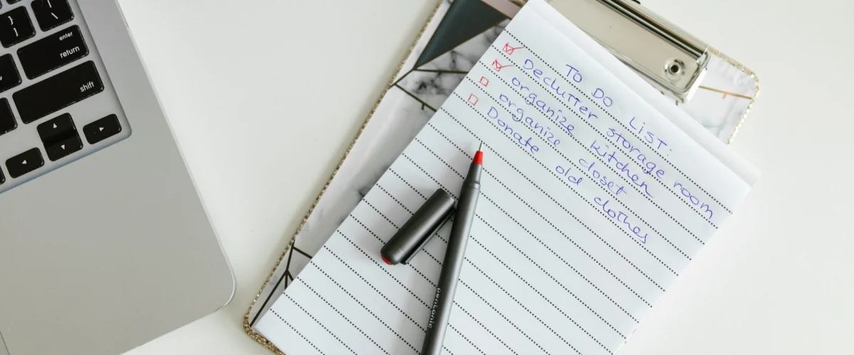 Change-Management Checkliste auf einem digitalen Tablet, daneben ein Stift und ein Notizblock, symbolisiert Planung und Umsetzung von Veränderungen