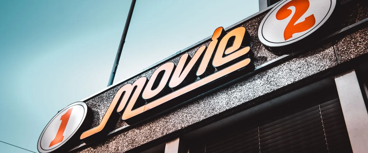 Filmklassiker Anleitung: Eine alte Filmrolle auf einem Tisch mit Notizblock und Stift, umgeben von Büchern über Filmgeschichte, symbolisiert das Analysieren von Meisterwerken.