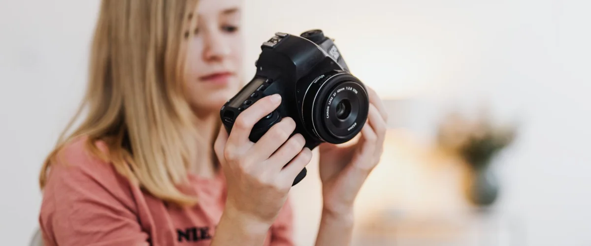 Fotograf finden – Eine Frau sucht online nach einem Fotografen finden, um ein Familienportrait zu erstellen, mit Laptop und Notizen.