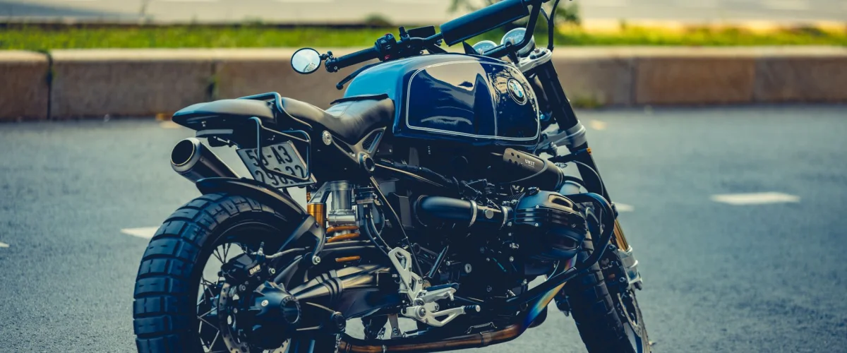 Motorrad Kosten im Überblick: Ein Fahrer sitzt auf einem Motorrad vor einer Landschaft, plant seine Ausgaben.