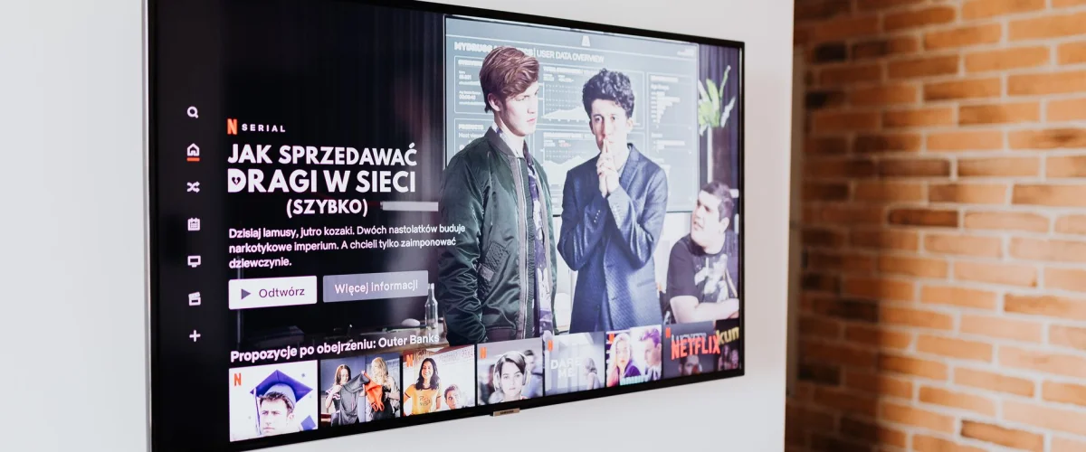 Smart-TV Test: Ein hochauflösender Fernseher zeigt ein farbenfrohes Bild, daneben eine Fernbedienung und ein Smartphone, die Smart-Funktionen symbolisieren.