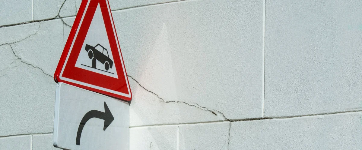Unfallversicherung Voraussetzungen – Eine Hand hält einen Schutzschild über eine andere, die ein Formular zur Unfallversicherung Voraussetzungen ausfüllt, symbolisiert Schutz und Vorsorge.