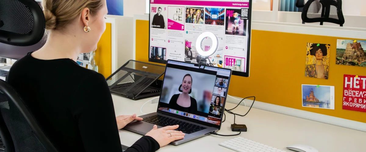 Videokonferenz einrichten – Eine Person richtet eine Videokonferenz ein, Laptop auf dem Tisch, Headset aufgesetzt, Fokus auf technische Vorbereitung.