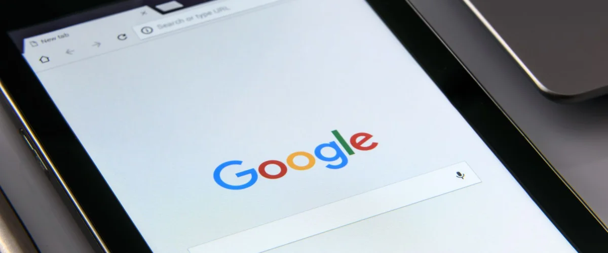 Google-Kategorien Kosten: Eine Lupe auf einem Smartphone-Bildschirm zeigt die Google Suche mit Kategorien, symbolisiert die Untersuchung von Gebühren.