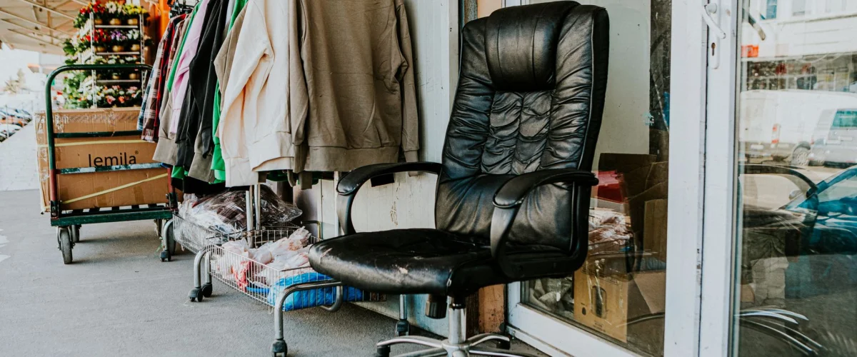 Secondhand Überblick: Eine Auswahl an gebrauchter Kleidung und Accessoires in einem Secondhand-Laden, die Nachhaltigkeit symbolisiert.
