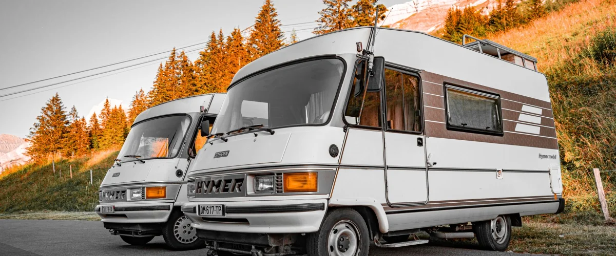 Wohnmobil Vergleich – Ein moderner Wohnmobil Vergleich zeigt verschiedene Modelle vor einer Bergkulisse, um die Auswahl zu erleichtern.